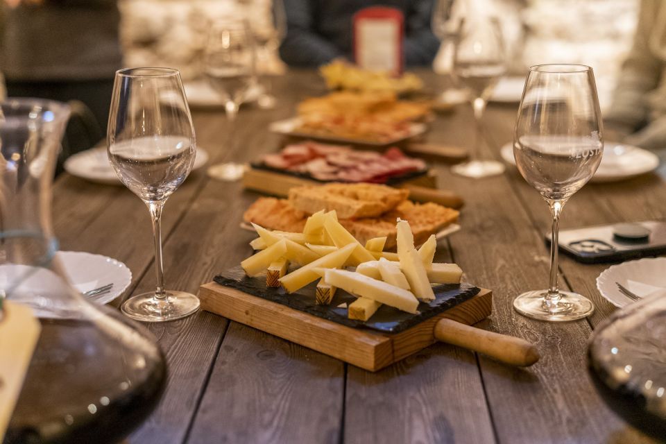 An image showing a table with a variety of different Spanish tapas, including local cheeses, bread with tomato and Iberian ham. 