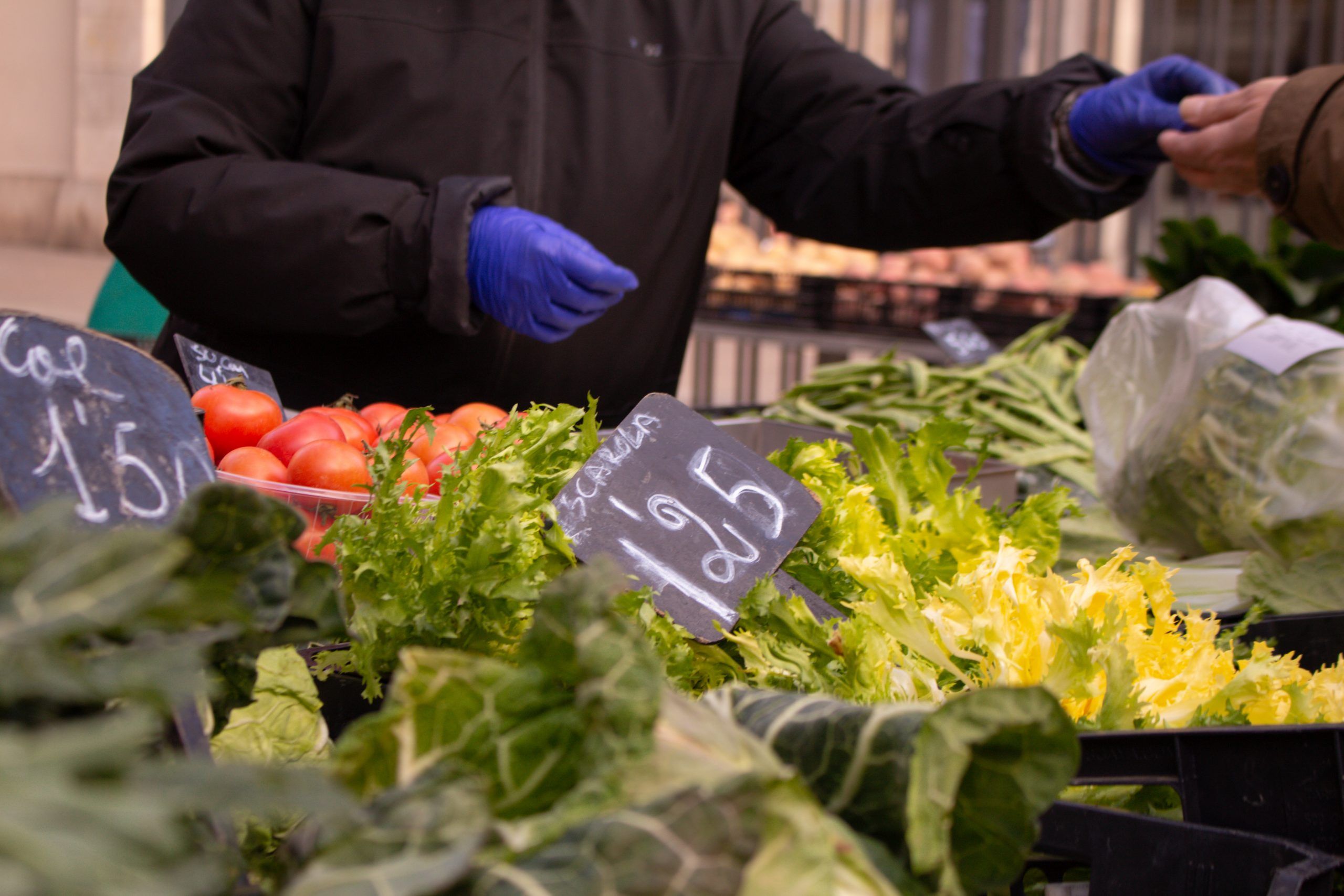 Puesto de verduras en el Mercado de La Boqueria de Barcelona vendiendo productos frescos.
